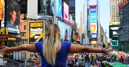 au pair med udstrakte arme på Times Square
