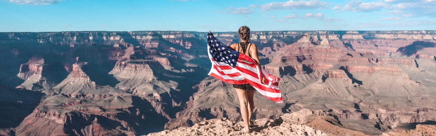 Au pair med et amerikansk flag ved Grand Canyon