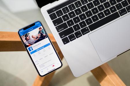 Smartphone og bærbar computer med Facebook-app