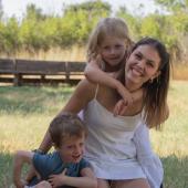 kvinde med to børn på en eng